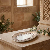 Decorative plate on a stone surface with floral arrangements in a warm-toned setting