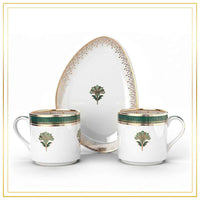 Set of ceramic dishes with green and gold floral patterns on a white background