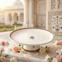 Decorative white plate with floral design on a marble surface with flowers and a blurred architectural background