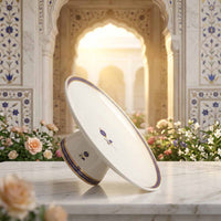 Decorative plate with floral patterns on a marble surface with an ornate architectural background