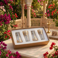 Set of four small bottles in a decorative box with floral and architectural background