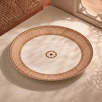 Decorative plate with intricate brown patterns on a textured surface
