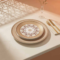 Decorative dinnerware set on a table with a glass of water and cutlery.