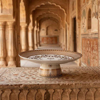 Decorative ceramic plate on a table with intricate patterns in a historic building setting
