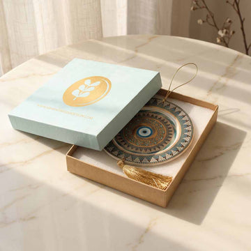 Decorative plate with tassel in a light blue box on a marble surface