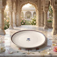 Decorative plate with floral design on a marble surface with architectural background