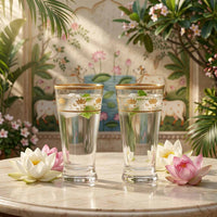Two glasses of water with floral decorations on a table with decorative background