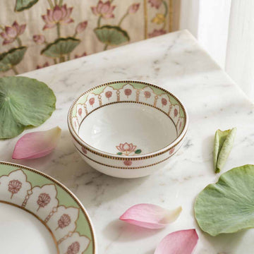 Decorative ceramic bowl with floral patterns on a marble surface with lotus leaves and petals.