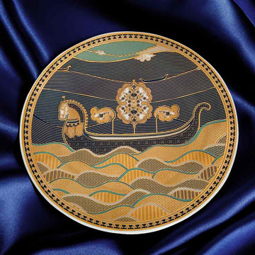 Decorative plate with a boat and floral design on a blue satin background