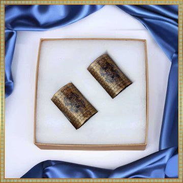 Pair of gold glasses in a box with blue satin fabric background